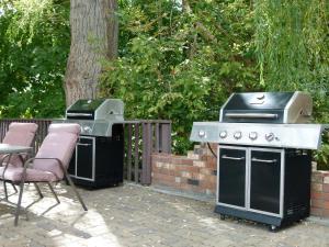 een grill en een barbecue met een tafel en stoelen bij Schell Motel in Vernon
