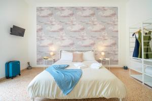 a bedroom with a large bed with clouds on the wall at Casa Risìu in Ragusa