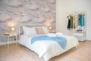 a bedroom with a bed with clouds on the wall at Casa Risìu in Ragusa