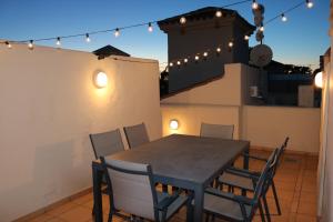 Roda Golf Resort ;Casa Sylva في سان خافيير: طاولة وكراسي على شرفة مع أضواء