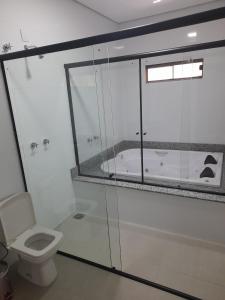 a bathroom with a shower and a toilet and a tub at Hotel Pimenta in Pimenta Bueno