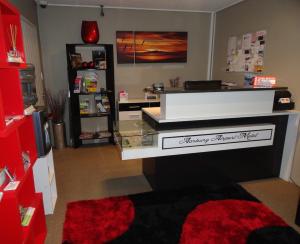 - un salon avec un bureau et un comptoir en verre dans l'établissement Aarburg Airport Motel, à Christchurch