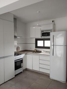 a white kitchen with white cabinets and a refrigerator at Mendoza Viejo Tonel in Mendoza