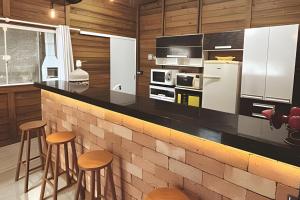 een keuken met een aanrecht en krukken. bij Rustic house - Prox Praia/BetoCarreiro in Penha