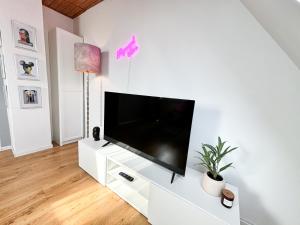 una sala de estar con TV de pantalla plana en un armario blanco en ThinkPink! Apartment Ennepetal * Sehr modern * Top Lage en Ennepetal