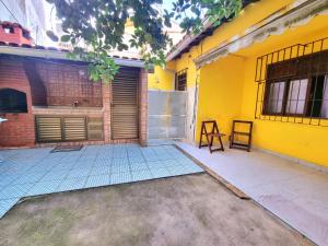 a yellow house with a door and a patio at Casa Praia Grande - Arraial do Cabo in Arraial do Cabo