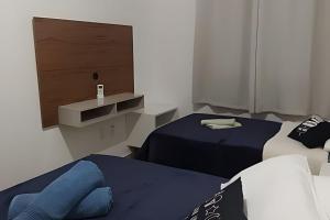 Zimmer mit 2 Betten und einem TV. in der Unterkunft Captiva Beach - 400m da PRAIA - WiFi - Netflix - Residencial Captiva in Navegantes