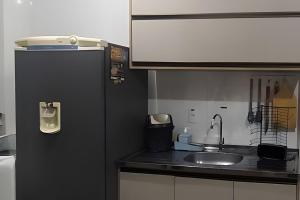 a kitchen with a black refrigerator and a sink at Captiva Beach - 400m da PRAIA - WiFi - Netflix - Residencial Captiva in Navegantes