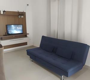 un sofá azul en la sala de estar con TV en Captiva Beach - 400m da PRAIA - WiFi - Netflix - Residencial Captiva en Navegantes