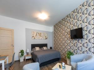 a bedroom with a bed and a tv on a wall at Ubytování v centru in Lanškroun