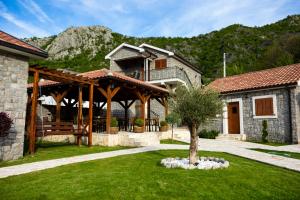 a house with a pavilion with a tree in the yard at Lake Valley in Virpazar