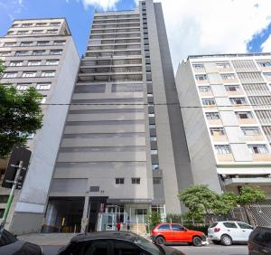 een hoog gebouw met auto's geparkeerd voor het bij BHomy Bela Vista Com sacada e conforto APM2008 in Sao Paulo