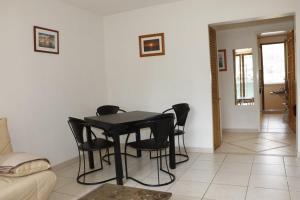ein Wohnzimmer mit einem Tisch und schwarzen Stühlen in der Unterkunft Gionova furnished flat in Aix-en-Provence