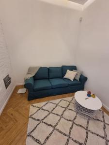 sala de estar con sofá azul y mesa en Квартира біля паркy en Umanʼ