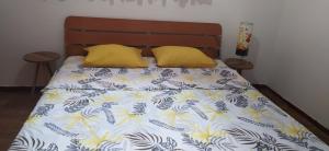 uma cama com duas almofadas amarelas em cima em Apartment Kjara em Tivat