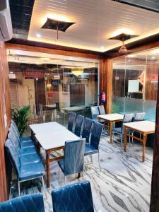 a restaurant with tables and chairs in a room at Hotel Vinayak Plaza in Varanasi