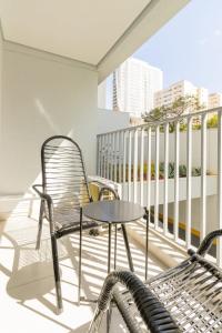 einen Balkon mit einem Tisch und Stühlen in der Unterkunft BHomy Brooklin - Charmoso com varanda BUR108 in São Paulo