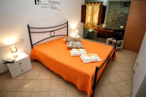 ein Schlafzimmer mit einem orangenen Bett mit Handtüchern darauf in der Unterkunft CASA DEL MORO in Trapani