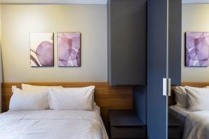 聖保羅的住宿－BHomy Brooklin - 300m estacão da Brooklin BUR101，一间卧室设有两张床,墙上挂有紫色画作