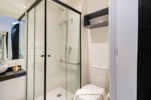 een badkamer met een toilet en een glazen douche bij BHomy Brooklin - 300m estacão da Brooklin BUR101 in Sao Paulo