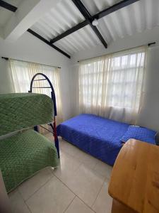 1 dormitorio con 1 cama, 1 silla y 1 ventana en Palma real, en La Mesa