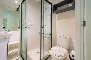 a bathroom with a toilet and a glass shower at BHomy Brooklin - Com varanda espaçosa BUR205 in Sao Paulo