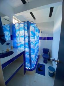 Baño azul con aseo y lavamanos en Palma real, en La Mesa