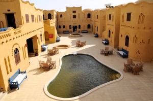 an empty courtyard with a swimming pool in a building at El Beyt Farmhotel in Az Zabū