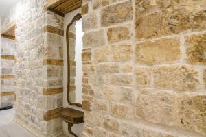 uma parede de pedra com um banco num quarto em Sobe Bartul Trogir em Trogir
