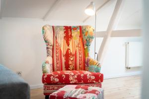 una silla colorida en una habitación con lámpara en Gemütliches Apartment, en Magdeburgo