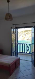 a bedroom with a bed and a view of the ocean at Thalassa house by the sea in Áyios Yeóryios