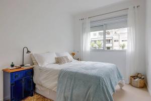 een witte slaapkamer met een bed en een raam bij BHomy Campeche Condomínio delicioso Spa club in Florianópolis