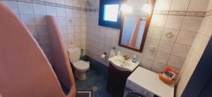 a small bathroom with a toilet and a sink at Thalassa house by the sea in Áyios Yeóryios