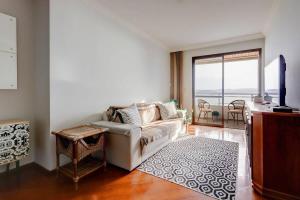 uma sala de estar com um sofá e uma grande janela em BHomy Centro Beira-mar norte com linda vista em Florianópolis