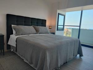 a bedroom with a large bed with a large window at Encantador depto 2D2B con estacionamiento vista al MAR ServicioHOM in Antofagasta