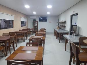 Hotel Pimenta في Pimenta Bueno: غرفة طعام مع طاولات وكراسي خشبية