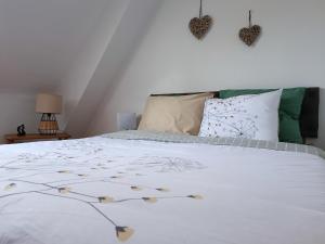 a bedroom with a bed with white sheets and pillows at Vue unique sur le Mont St Michel in Huisnes-sur-Mer