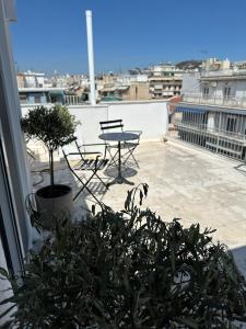 a patio with a table and a bench on a roof at Graffiti Roof in Athens