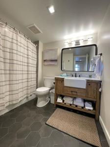 a bathroom with a sink and a toilet and a mirror at Ski In-Out Hot Tub Gym Sauna Pool Reserved Parking-503 in Brighton