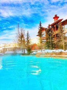 a large pool of blue water in front of a building at Ski In-Out Hot Tub Gym Sauna Pool Reserved Parking-503 in Brighton