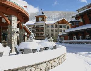 un edificio con mesa y sillas en la nieve en Ski In-Out Hot Tub Gym Sauna Pool Reserved Parking-503 en Brighton