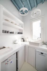 a white kitchen with white counters and a window at Chiara Mykonos III in Mýkonos City