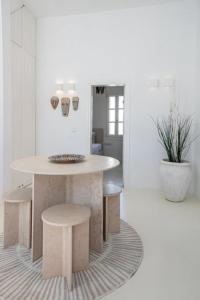 a white room with a table and a table and stool at Chiara Mykonos III in Mýkonos City