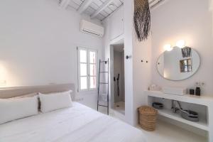 a white bedroom with a white bed and a mirror at Chiara Mykonos III in Mýkonos City