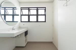 uma casa de banho branca com um lavatório e um espelho em BHomy Paulista - Perfeita localizacao MR173 em São Paulo