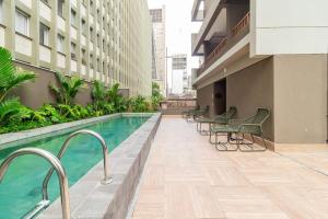 um edifício com piscina e cadeiras e um edifício em B Homy Paulista - 270m do Trianon Masp PLO1406 em São Paulo
