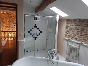 uma casa de banho com um chuveiro e uma banheira branca em Au coeur des loges em Saint-Bonnet-de-Bellac