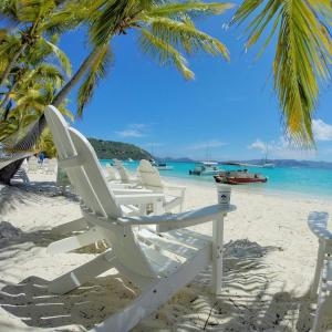 Caribbean Life in St. Thomas في Bolongo: مجموعة من الكراسي على الشاطئ