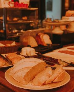 une table recouverte de assiettes de pain et de sandwichs dans l'établissement Hotel Comoditá Ltda, à Sapiranga