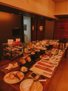 a buffet with many plates of food on a table at Hotel Comoditá Ltda in Sapiranga